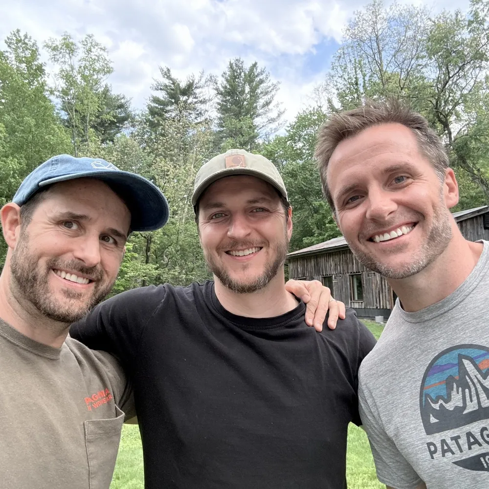 Ryan with Derek and Steve, the Camerado partners, in front of a barn
